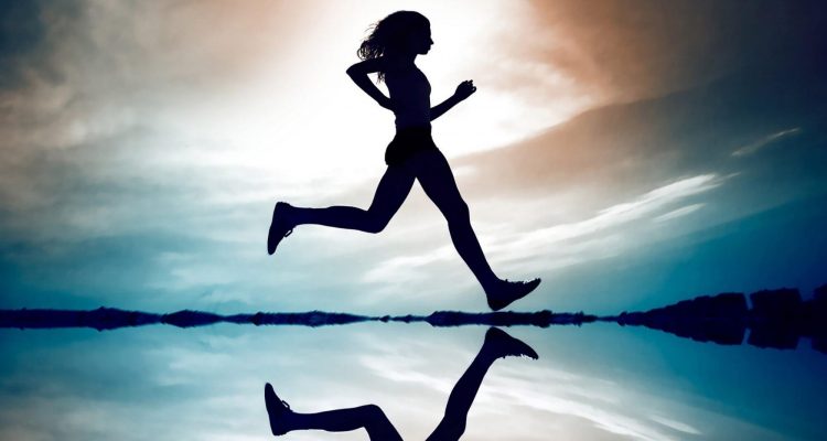Person moving gracefully from one yoga pose to another in a spacious studio.
